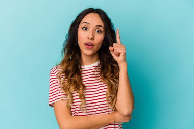 Genç Meksikalı bir kadın mavi arka planda izole edilmiş. Harika bir fikri var. Yaratıcılık kavramı..