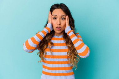 Mavi arka planda izole edilmiş genç Meksikalı kadın şok geçiriyordu. Önemli bir buluşmayı hatırladı..