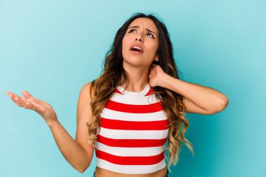 Mavi arka planda izole edilmiş genç Meksikalı kadın öfkeyle bağırıyor..