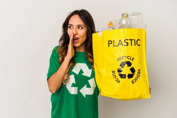 白地に隔離されたプラスチックをリサイクルする若いメキシコ人女性は秘密のホットブレーキニュースと脇を見ている — ストック写真