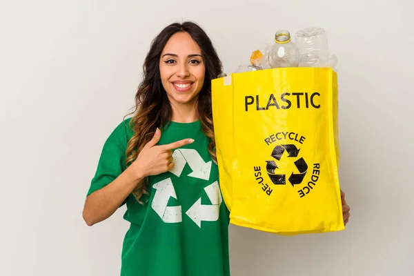 年轻的墨西哥妇女在回收塑料时 把塑料隔离在白色的背景上 面带微笑地指着旁边 在空白的空间里展示着一些东西 — 图库照片