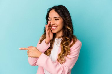 Mavi arka planda izole edilmiş genç Meksikalı bir kadın bir dedikodu söylüyor, bir şeyi haber veriyor..