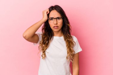 Pembe arka planda izole edilmiş genç Meksikalı kadın bir şeyi unutuyor. Alnına avuç içi ve gözlerini kapatarak vuruyor..