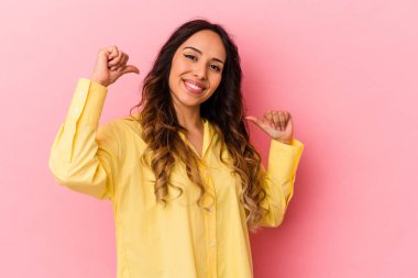 Pembe arka planda izole edilmiş genç Meksikalı kadın kendini gururlu ve kendinden emin hissediyor..