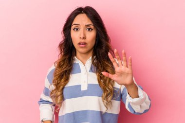 Pembe arka planda izole edilmiş genç Meksikalı kadın yakın bir tehlike nedeniyle şoka uğruyor.