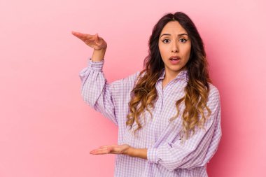 Pembe arka planda izole edilmiş genç Meksikalı kadın elleri arasında bir fotokopi alanı tutuyor..