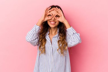 Pembe arka planda izole edilmiş genç Meksikalı kadın heyecanlı..