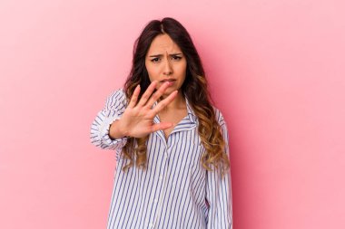 Pembe arka planda izole edilmiş genç Meksikalı kadın tiksinti belirtisi gösteren birini reddediyor..