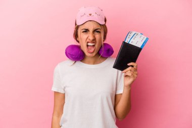 Elinde pasaport ve seyahat biletleri olan beyaz saçlı genç bir kadın pembe arka planda çok sinirli ve agresif bir şekilde bağırıyor..