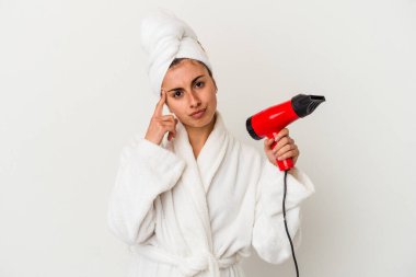 Kafkasyalı genç bir kadın elinde saç kurutma makinesi ile beyaz bir tapınağa izole edilmiş, parmağıyla düşünen, bir göreve odaklanmış..