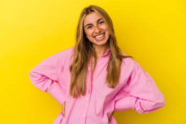 Sarışın, beyaz bir kadın. Sarı arka planda izole edilmiş. Mutlu, güler yüzlü ve neşeli..