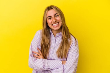 Sarışın, beyaz bir kadın. Sarı arka planda izole edilmiş. Gülüyor ve eğleniyor..