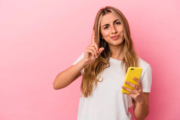 Jovem Loira Caucasiana Segurando Telefone Celular Amarelo Isolado Mostrando Número — Fotografia de Stock