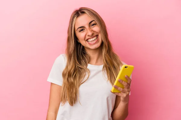 Молодая Блондинка Кавказская Женщина Держит Желтый Мобильный Телефон Изолирован Счастливый — стоковое фото