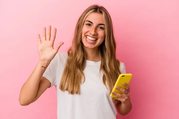 Joven Rubia Caucásica Sosteniendo Teléfono Móvil Amarillo Aislado Sonriendo Alegre —  Fotos de Stock