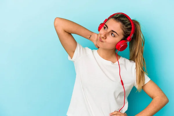 Genç Sarışın Kadın Kulaklıkla Müzik Dinliyor Mavi Arka Planda Izole — Stok fotoğraf