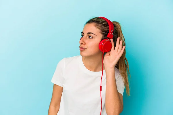 Jovem Loira Ouvindo Música Fones Ouvido Isolados Fundo Azul Tentando — Fotografia de Stock