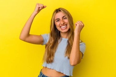 Sarışın, beyaz bir kadın sarı arka planda dans ediyor ve eğleniyor..