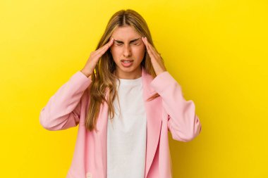 Sarışın, beyaz bir kadın, sarı arka planda izole edilmiş, başı ağrıyor, yüzüne dokunuyor..