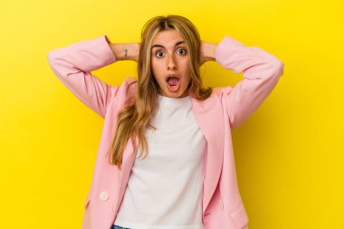 Sarı arka planda izole edilmiş genç sarışın kadın çığlık atıyor, çok heyecanlı, tutkulu, bir şeyden memnun..