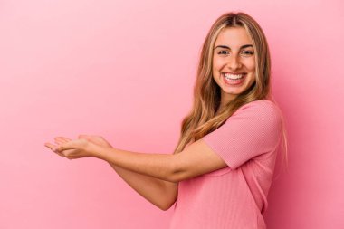 Sarışın, beyaz bir kadın pembe arka planda izole edilmiş. Elinde palmiye ağacında bir fotokopi odası var..