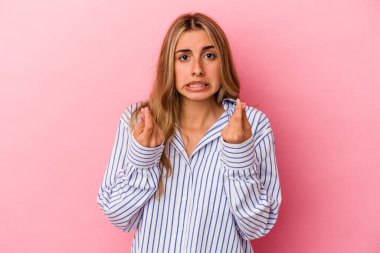 Pembe arka planda izole edilmiş genç sarışın kadın parasız olduğunu gösteriyor..