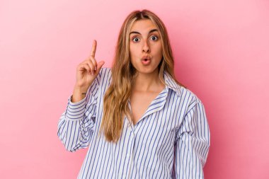 Pembe arka planda izole edilmiş, ağzı açık genç sarışın kadın..