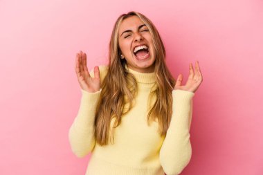 Pembe arka planda soyutlanmış genç sarışın beyaz kadın kahkahalarla gülüyor..