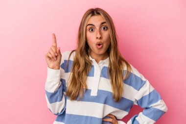 Pembe arka planda soyutlanmış genç sarışın kadın. Bir fikri var, ilham verici bir kavram..