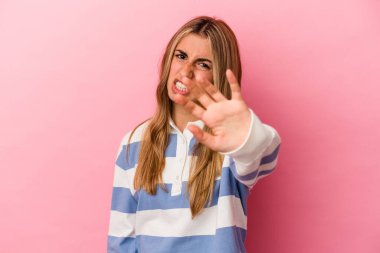 Pembe arka planda izole edilmiş genç sarışın kadın tiksinti belirtisi gösteren birini reddediyor..