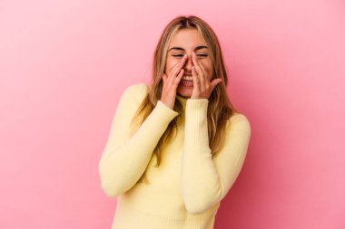 Sarışın, beyaz bir kadın pembe arka planda izole edilmiş. Dedikodu yapıyor, bir şeyleri bildiriyor..