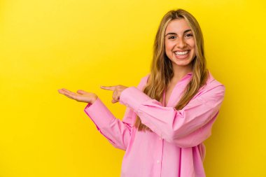 Sarışın, beyaz bir kadın. Sarı arka planda izole edilmiş. Elinde bir fotokopi odası olduğu için heyecanlı..