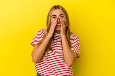 Sarışın, beyaz bir kadın. Sarı arka planda izole edilmiş. Dedikodu yapıyor..