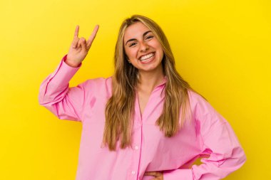 Sarışın, beyaz bir kadın sarı arka planda izole edilmiş. Boynuzları devrim hareketi olarak gösteriyor..