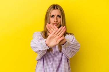 Sarışın, beyaz bir kadın, sarı arka planda izole edilmiş, inkar hareketi yapıyor.