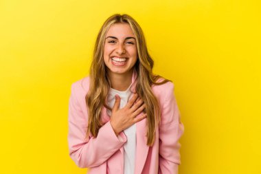 Sarışın, beyaz bir kadın. Sarı arka planda izole edilmiş. Yüksek sesle gülüyor..