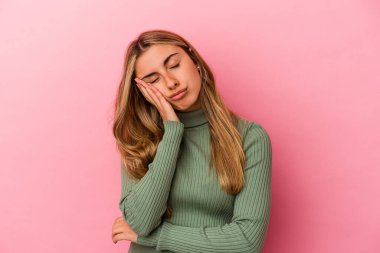 Pembe arka planda izole edilmiş genç sarışın kadın sıkılmış, yorgun ve dinlenmeye ihtiyacı var..