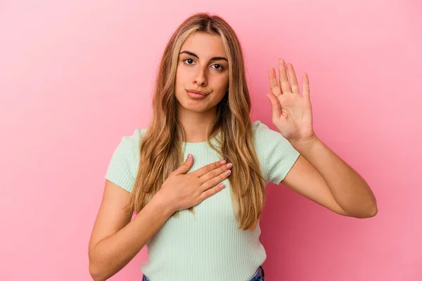 Joven Rubia Caucásica Aislada Sobre Fondo Rosa Haciendo Juramento Poniendo —  Fotos de Stock