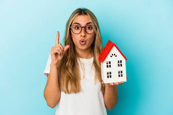 Young Caucasian Woman Holding House Model Isolated Blue Background Having — Stock Photo, Image