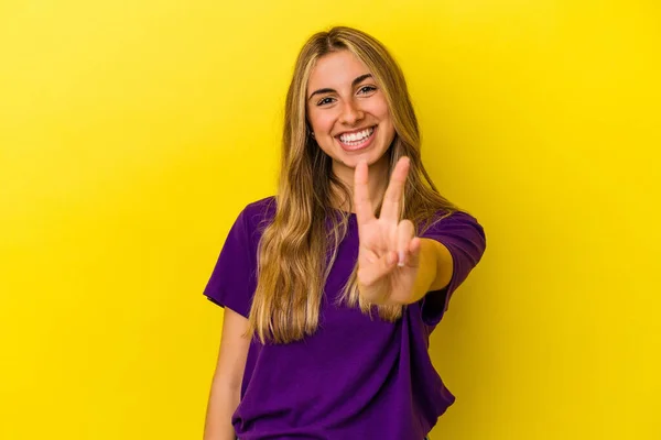 Sarı Arka Planda Izole Edilmiş Genç Sarışın Kadın Zafer Işareti — Stok fotoğraf