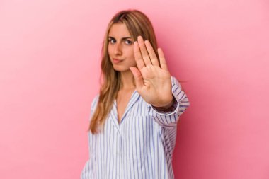 Pembe arka planda izole edilmiş genç sarışın kadın yakın bir tehlike nedeniyle şoka uğruyor.