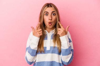 Pembe arka planda izole edilmiş, ağzı açık genç sarışın kadın..