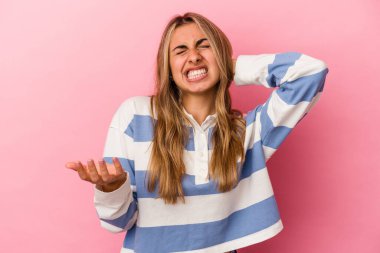 Pembe arka planda izole edilmiş genç sarışın kadın öfkeyle bağırıyor..