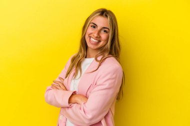 Sarışın, beyaz bir kadın. Sarı arka planda izole edilmiş. Gülüyor ve eğleniyor..