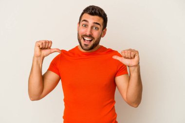 Beyaz arka planda izole edilmiş genç beyaz adam gururlu ve kendinden emin hissediyor, örnek olarak..