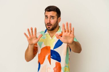 Beyaz arka planda izole genç beyaz adam yakın bir tehlike nedeniyle şoka uğruyor