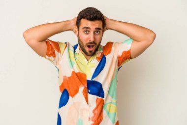 Beyaz arka planda izole olmuş genç beyaz bir adam çığlık atıyor, çok heyecanlı, tutkulu, bir şeyden memnun..