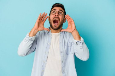 Mavi arka planda izole edilmiş beyaz bir adam heyecanlı bir şekilde bağırıyor..