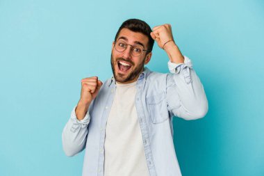 Genç beyaz adam mavi arka planda izole edilmiş dans ediyor ve eğleniyor..