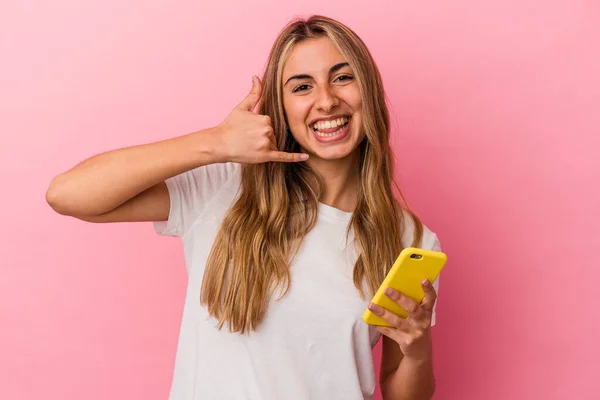 Joven Rubia Caucásica Sosteniendo Teléfono Móvil Amarillo Aislado Mostrando Gesto —  Fotos de Stock